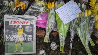 Flowers, candles, and a sign that reads "All of our thoughts are for you Emiliano Sala" are left with newspaper 'L'Equipe' in La Chapelle-sur-Erdre. AFP