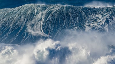 A surfer rides a wave in Nazare, Portugal. Getty images