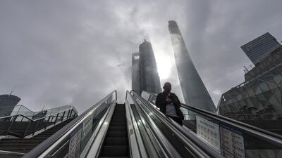 A pedestrian descends an escalator in Lujiazui Financial District in Shanghai. Bloomberg