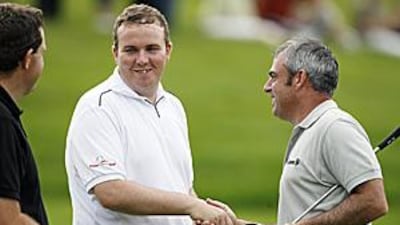 Shane Lowry shakes hands with compatriot Paul McGinley, right, after completing his first professional round of golf on the first day of the European Open at the London Club yesterday.