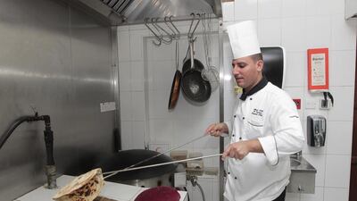 Abdulatif Ghandoor, oriental chef at Arabian Courtyard, cooking traditional Emirati bread at the Barjeel Guest House. Jeffrey E Biteng / The National
