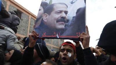Mourners hold a placard of Chokri Belaid during his funeral procession in Tunis February. Anis Mili / Reuters