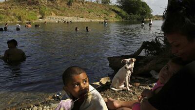 A boy eats a sausage on a stick on February 16, 2014, during a picnic with his family by the banks of Pacora River, on the outskirts of Panama City. The banks of Pacora River, which runs under one of the bridges of the Pan-American Highway, is a popular location during the dry season for the city dwellers to spend the day barbecuing and picnicking with their families. Carlos Jasso / Reuters
