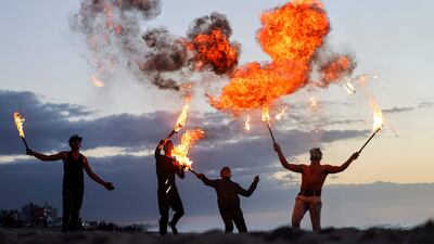 Palestinian youth show their fire breathing skills along the beach in Gaza city.