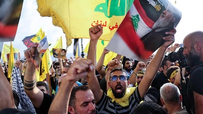 Hezbollah supporters raise the party's yellow flags and pictures of its slain leader Hassan Nasrallah, as they mark the first anniversary of his killing. AFP