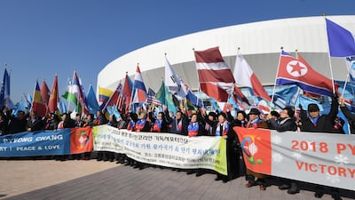 South Koreans hold the national flag of North Korea and other participating countries of the 2018 PyeongChang Winter Olympics. EPA/YONHAP