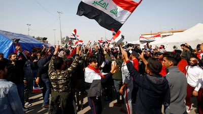 Iraqi demonstrators hold the Iraqi flag as they chant slogans during ongoing anti-government protests in Najaf, Iraq February 6, 2020. Reuters