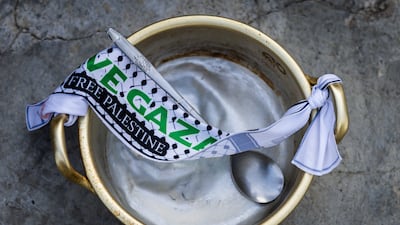 A pot and spoon symbolising the hunger faced by Palestinian children during the war in Gaza, alongside a banner reading 'Free Palestine' are seen during a solidarity march in Kuala Lumpur, Malaysia, on August 2. Getty Images