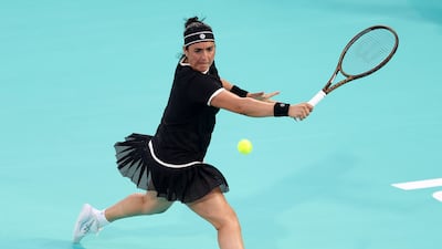 Ons Jabeur stretches to reach a backhand.