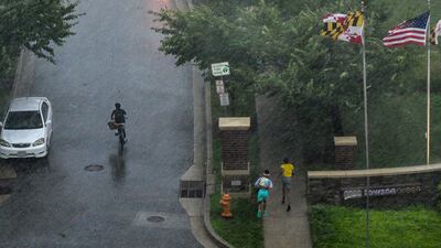 People seek shelter as a line of thunderstorms hit downtown Towson. The Baltimore Sun / AP