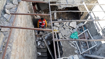 A Palestinian medic checks a damaged house where Israeli forces killed Palestinian gunmen in the occupied West Bank. Reuters