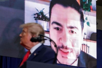 A video of Michigan Democratic Senate candidate Abdul El-Sayed is displayed behind US President Donald Trump as he delivers remarks during an election rally in Port Huron, Michigan. AFP