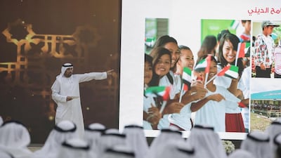 Emirates Red Crescent secretary general Mohammed Al Falahi at the Crown Prince Majlis alongside the image of the Filipino schoolgirls pleased that UAE aid helped rebuild their school. Courtesy Crown Prince Court