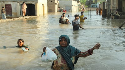 Villager Jannat Mai wades through a flooded street to a rescue boat during evacuations from Daryapur, near Jalalpur Pirwala, in Punjab province, Pakistan. The nearby Chenab river has breached its banks in monsoon rains. Reuters