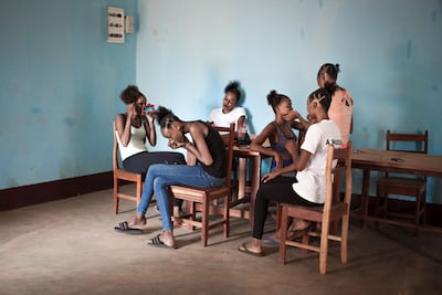 A Miss Central African Republic 2018 contestants puts on make-up at the boarding school where the contestants reside before the contest. AFP