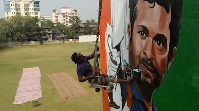 A man paints a mural of Sachin Tendulkar at a building overlooking a cricket pitch in Mumbai. Tendulkar will begin his final Test with India on Thursday. Punit Paranjpe / AFP