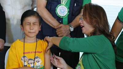 Filipino health secretary Janette Garin administers an anti-dengue jab to a schoolgirl in Marikina city yesterday. Francis Malasig / EPA