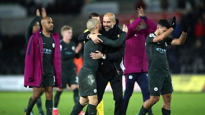 Pep Guardiola celebrates with his Manchester City players after their 15th successive Premier League win came with a 4-0 triumph at Swansea City. Nick Potts / PA via AP