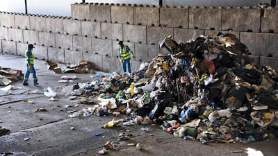 Workers inspect unsorted rubbish at RAK's new recycling facility. The process would be much more efficient if households were able to sort plastics, cans and food waste into separate boxes