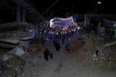 People walk under decorative lights put up for Ramadan on a street in Khan Younis, in southern Gaza. Reuters