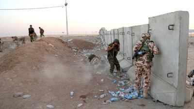 Kurdish peshmerga fighters take cover during airstrikes targeting Islamic State militants near the Khazer checkpoint outside of the city of Erbil in northern Iraq, on August 8, 2014. Khalid Mohammed / AP Photo
