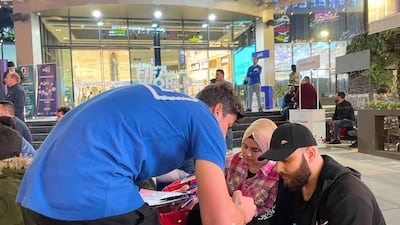 A man distributes sweepstake tickets on who will lift the World Cup, with a tablet on offer for the winner