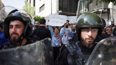 A woman holds a placard reading 'We will not allow our children to die at the doors of private hospitals' during the rally calling for better living conditions, in Damascus. Reuters