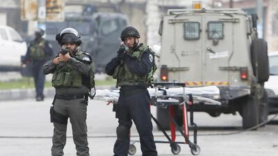 Israeli border police point their weapons at the scene where a 73-year-old Palestinian woman was shot dead by Israeli troops, near to the West Bank city of Hebron on November 6, 2015. Mussa Qawasma/Reuters