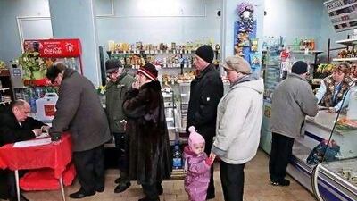 Russian people receive their ballot papers at a mobile polling station inside a shop in the village of Yerino 20 kilometres from Moscow yesterday.