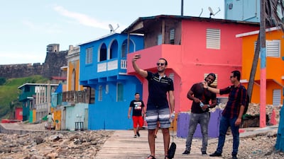 A man takes a selfie with his friends in the neighbourhood of La Perla. Ricardo Arduengo / AFP