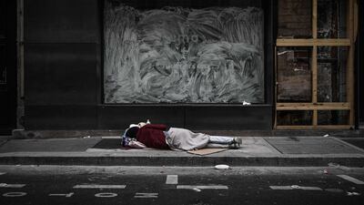 A homeless sleeps in front of closed shops in Paris, France. AFP