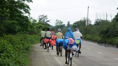 Workers on bicycles on their way to their native places in Bihar from Golaghat district, at Nalbari district of Assam, May 24. EPA