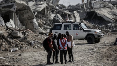 Members of the Qassam Brigades, the armed wing of Hamas, and a Red Cross team search for the bodies of Israeli hostages in Jabalia refugee camp, northern Gaza. Bloomberg