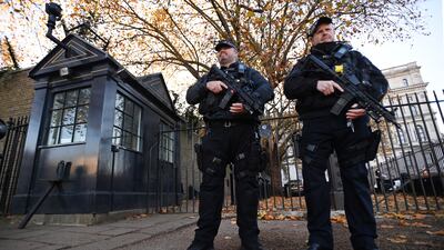 Armed police outside Downing Street in London. The UK terrorism threat level has been lowered. EPA