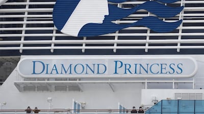 Masked passengers look on from on board the coronavirus-hit Diamond Princess cruise ship docked at Yokohama Port, south of Tokyo, Japan, February 20, 2020. REUTERS/Kim Kyung-Hoon