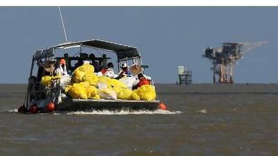 Cleanup workers bring in a load of contaminated oil-absorbent booms from the Gulf of Mexico. John Moore / Getty Images