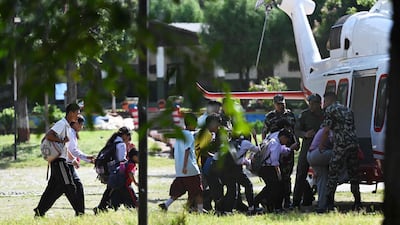 School pupils board a helicopter to join their families at Trishuli camp, after being stranded by the floods. AFP