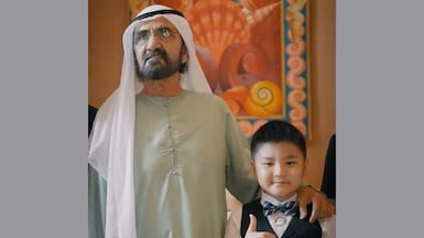 Sheikh Mohammed bin Rashid, Vice President and Ruler of Dubai, meets Roger Xie, a young child who wrote a message of thanks for keeping UAE safe. Photo: Dubai Media Office