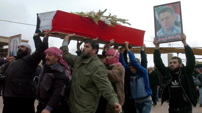 Mourners carry the coffin of Rafat Nashat during a mass funerals in Sweida province, Syria. SANA via AP