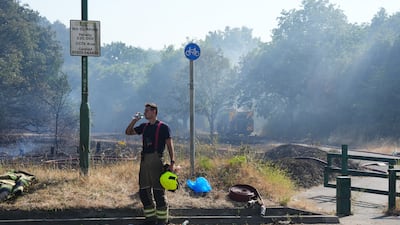 A firefighter has a drink of water after the major blaze on Dartford Heath. Getty