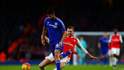 Per Mertesacker of Arsenal fouls Diego Costa, which results in a red for the defender on Sunday night in his team’s Premier League loss. Clive Mason / Getty Images