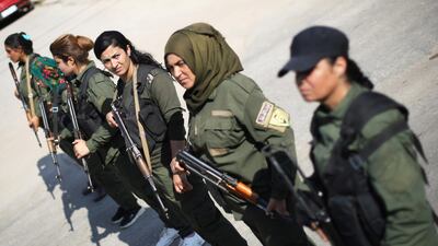 Kurdish policewomen stand guard as Kurdish and Arab protesters take part in a march against Turkish President and walk to the United Nations Headquarters in the town of Qamishli, Syria. REUTERS