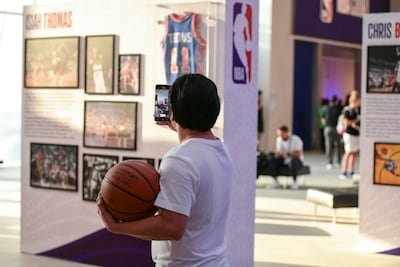 A fan takes a photo of an exhibition in the NBA District in Manarat Al Saadiyat. Khushnum Bhandari / The National
