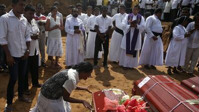 A woman reacts next to a coffin of a relative. Reuters