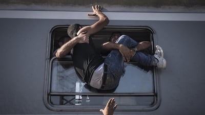 A handout image provided by the World Press Photo (WPP) organisation on 18 February 2016 shows a picture by Russian photographer Sergey Ponomarev for The New York Times that won First Prize Stories in the General News Category of the 59th annual World Press Photo Contest, it was announced by the WPP Foundation in Amsterdam, The Netherlands on 18 February 2016. The picture shows migrants struggling to climb onto a train headed to Zagreb, the Croatian capital. Under Europe’s system of open internal borders, the island’s thinly patrolled, easily accessible coastline, within sight of the Turkish coast, might as well be the frontier of France or Germany or Sweden. Sergey Ponomarev / EPA
