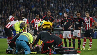 Manchester United players look on as Luke Shaw receives treatment after sustaining an injury. Reuters
