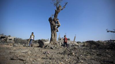 Palestinian children play at the site of an Israeli military strike in Gaza City on Tuesday. Israeli warplanes pounded Gaza with more than 50 strikes after Hamas militants fired scores of rockets over the border, dragging the two sides towards a major conflict. Mohammed Abed / AFP PHOTO
