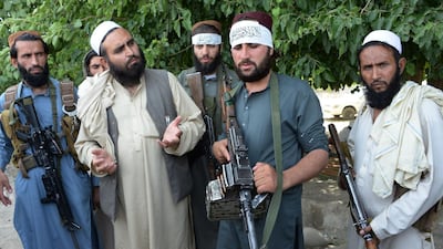 Afghan Taliban militants stand with a resident as they celebrate the ceasefire on the second day of Eid in the outskirts of Jalalabad. AFP