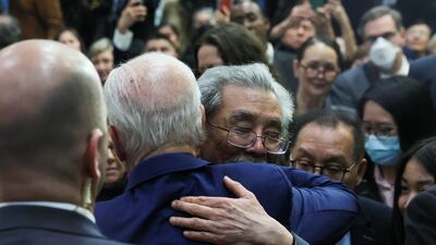 US President Joe Biden hugs a man in Monterey Park on March 14. Reuters