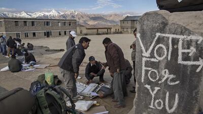 Election workers check voting machines before leaving a central collection point for polling stations.